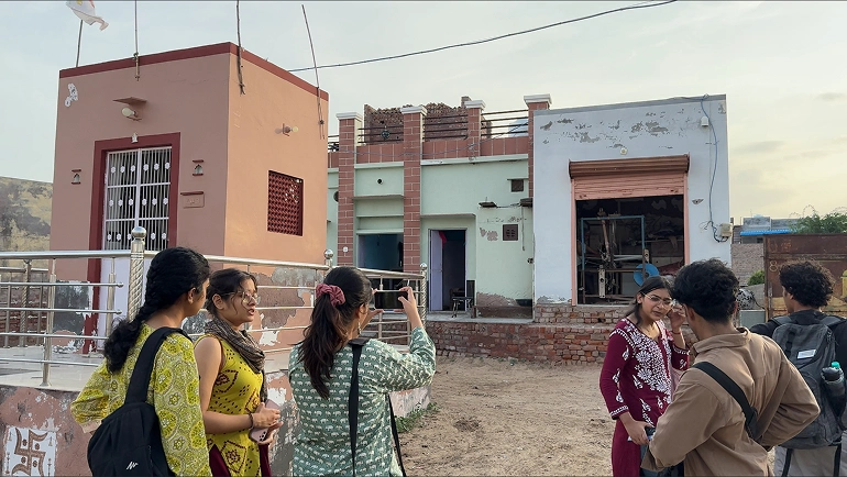 Our team talking outside a village home and workshop during field visits