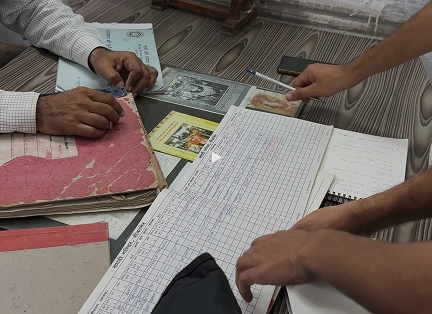 Checking artisans' payment records at the khadi mandir