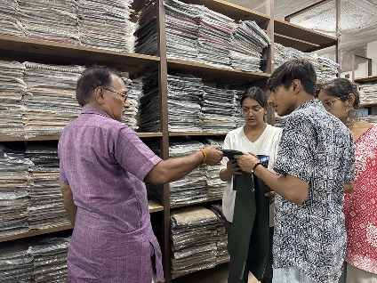 A khadi store manager showing woven wool stock from the shelves to the team